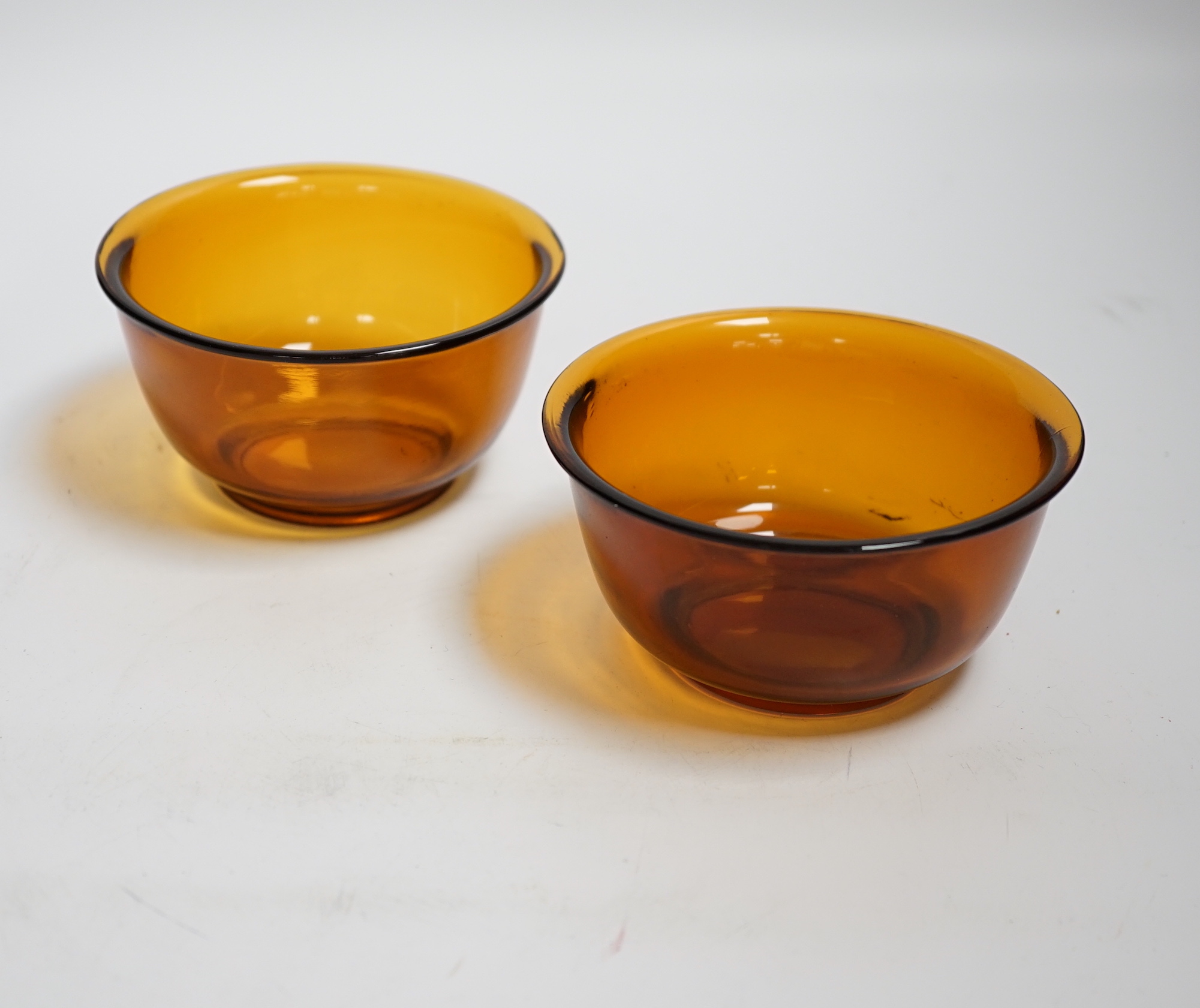 A pair of Chinese Beijing amber glass bowls, 11cm diameter